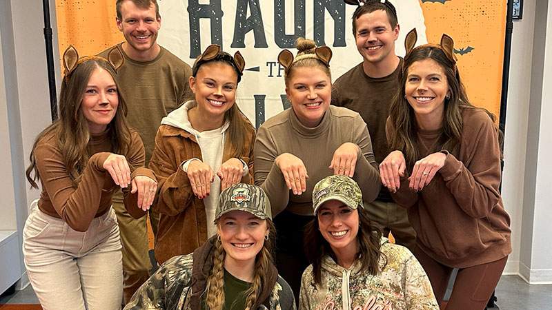 Team members in themed costumes at an office Halloween event
